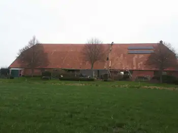 Volledige dakvernieuwing met hergebruik van oude pannen op boerderij in Beerte