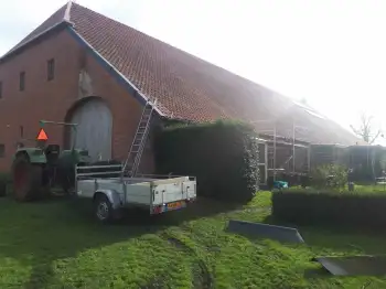 Volledige dakvernieuwing met hergebruik van oude pannen op boerderij in Beerte