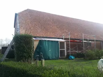 Volledige dakvernieuwing met hergebruik van oude pannen op boerderij in Beerte